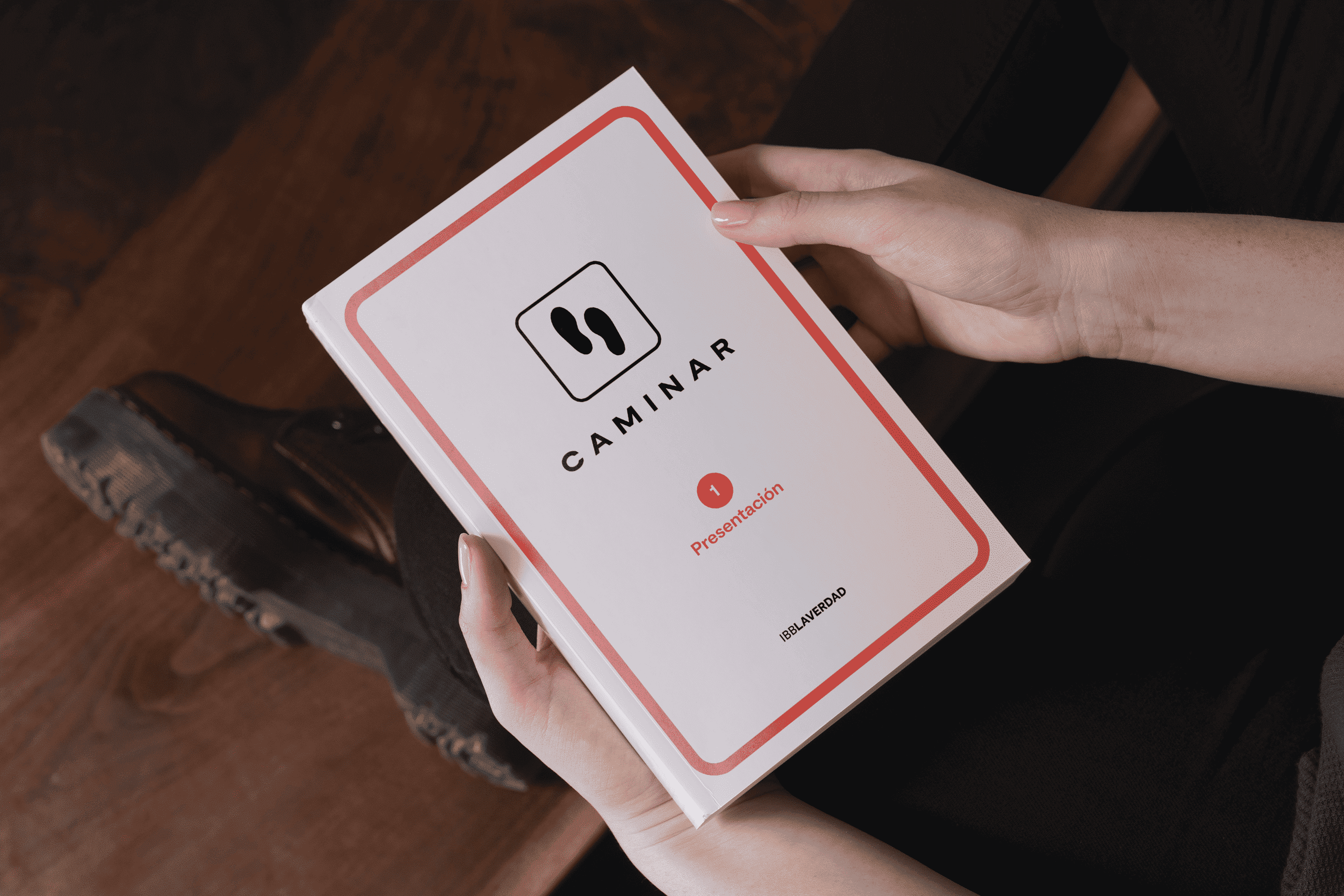 Persona sosteniendo un manual del curso Caminar